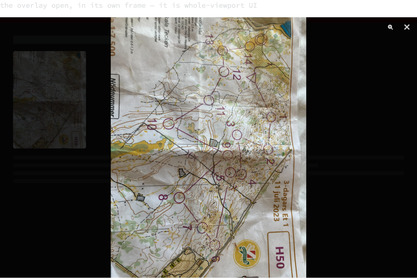 A browser-sized frame showing the lightbox open: the page dimmed behind a dark scrim, the full race map scan fitted to the height of the frame, and a zoom and a close button in the top right corner.