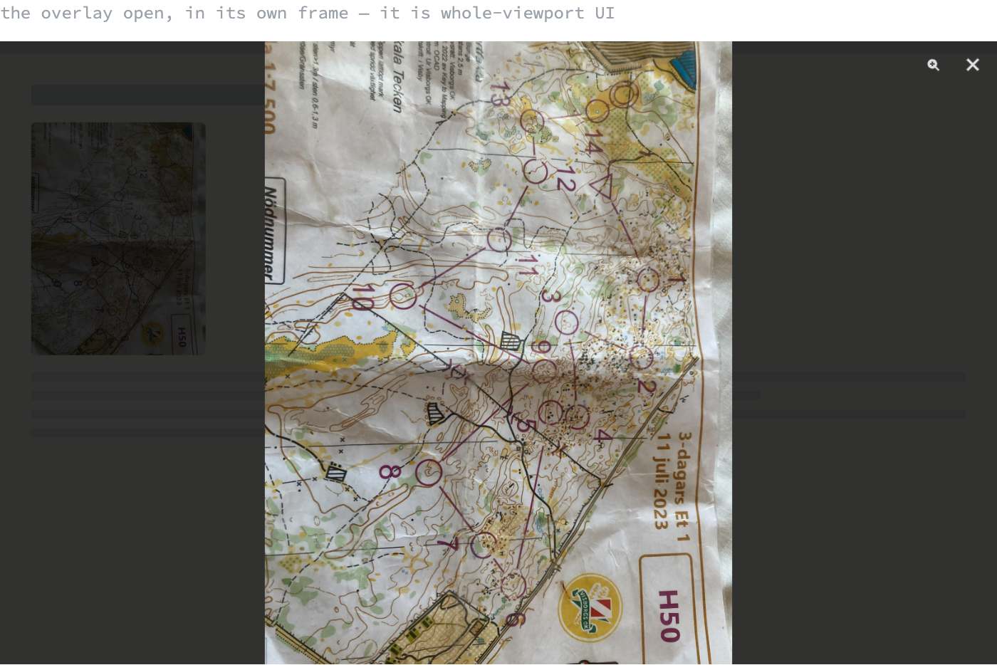 A browser-sized frame showing the lightbox open: the page dimmed behind a dark scrim, the full race map scan fitted to the height of the frame, and a zoom and a close button in the top right corner.