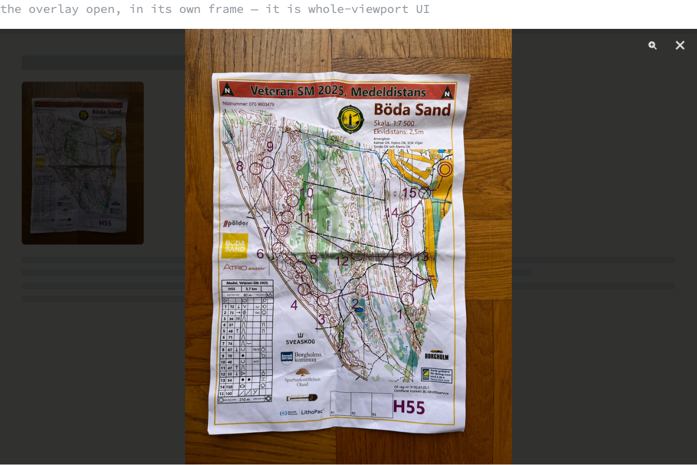 A browser-sized frame showing the lightbox open: the page dimmed behind a dark scrim, the full race map scan fitted to the height of the frame, and a zoom and a close button in the top right corner.